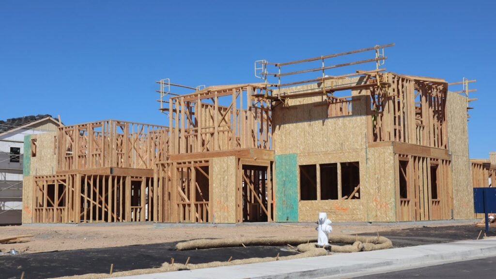 image of a construction site featuring ongoing property development, with architectural plans, equipment, and workers collaborating on a building project.